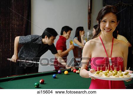 Party host with plate of appetizers, smiling at camera, people in the background View Large Photo Image Picture - Party host with plate of appetizers, smiling at camera, people in the background. Fotosearch