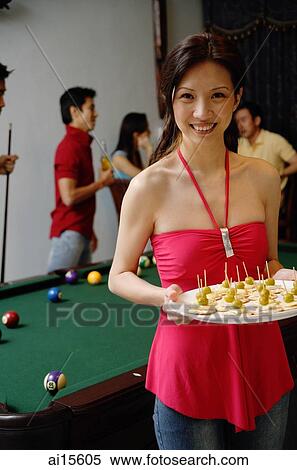 Stock Photography - Party host with plate of appetizers, smiling at camera. Fotosearch