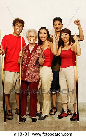 Stock Image - Three generation family, looking at camera, smiling. Fotosearch