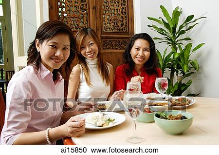 Three women having a meal at restaurant View Large Photo Image Stock Image - Three women having a meal at restaurant. Fotosearch