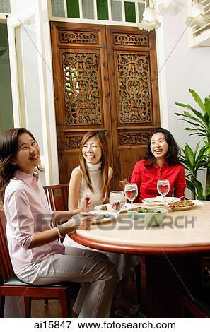 Three women having a meal at restaurant, laughing View Large Photo Image Stock Photo - Three women having a meal at restaurant, laughing. Fotosearch