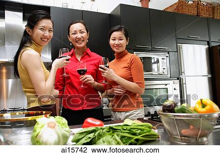 Three women in kitchen, holding wine glasses, looking at camera View Large Photo Image Stock Image - Three women in kitchen, holding wine glasses, looking at camera. Fotosearch