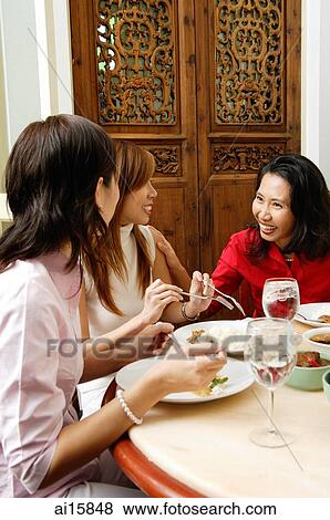 Stock Photo - Three women in restaurant, talking. Fotosearch