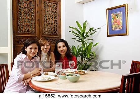 Three women sitting at a restaurant with food on table View Large Photo Image Stock Image - Three women sitting at a restaurant with food on table. Fotosearch