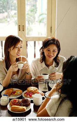 Three women sitting in cafe, having tea View Large Photo Image Stock Image - Three women sitting in cafe, having tea. Fotosearch