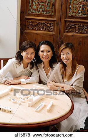 Three women sitting next to each other, at mahjong table, smiling View Large Photo Image Stock Photo - Three women sitting next to each other, at mahjong table, smiling. Fotosearch