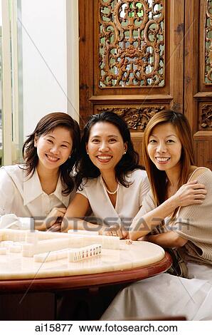 Three women sitting side by side, smiling View Large Photo Image Stock Photo - Three women sitting side by side, smiling. Fotosearch