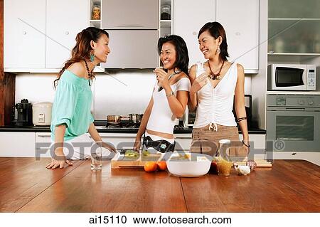 Three women standing in kitchen, laughing View Large Photo Image Stock Image - Three women standing in kitchen, laughing. Fotosearch