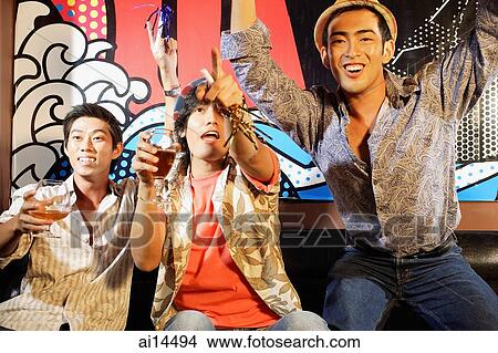 Three young men, at entertainment club, arms raised, looking forward View Large Photo Image Picture - Three young men, at entertainment club, arms raised, looking forward. Fotosearch