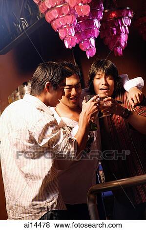 Three young men, toasting at entertainment club View Large Photo Image Stock Photo - Three young men, toasting at entertainment club. Fotosearch