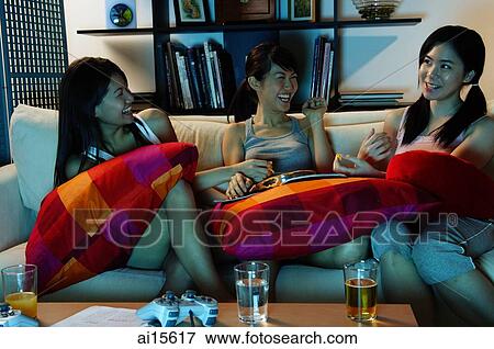 Three young women in living room, sitting on sofa, talking View Large Photo Image Stock Photo - Three young women in living room, sitting on sofa, talking. Fotosearch