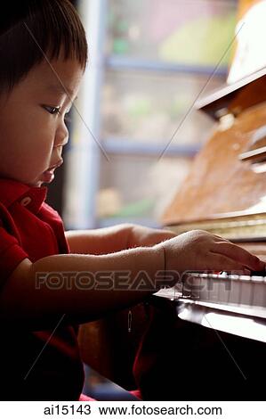 Stock Image - Toddler playing on piano. Fotosearch