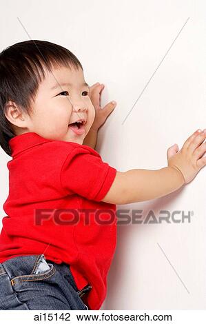 Toddler standing and leaning on wall, smiling View Large Photo Image Stock Image - Toddler standing and leaning on wall, smiling. Fotosearch
