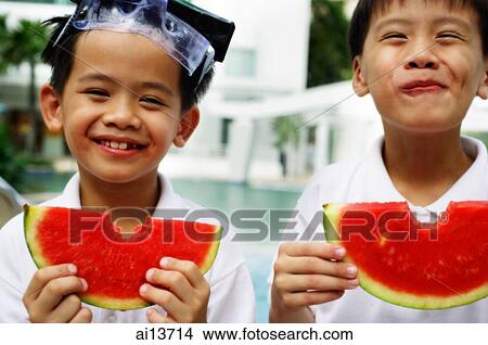 Picture - Two boys holding slices of watermelon, smiling. Fotosearch