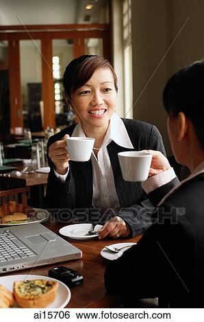 Two businesswomen at cafe, drinking coffee View Large Photo Image Stock Photograph - Two businesswomen at cafe, drinking coffee. Fotosearch