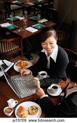 Stock Photo - Two businesswomen at cafe with laptop. Fotosearch