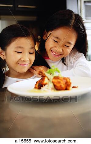 Two children looking at a plate of food, smiling View Large Photo Image Stock Photography - Two children looking at a plate of food, smiling. Fotosearch