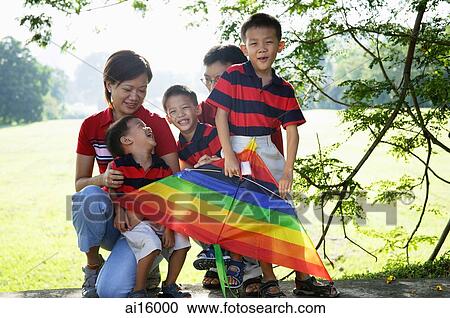 Stock Image - Two generation family, outdoors, smiling at camera. Fotosearch