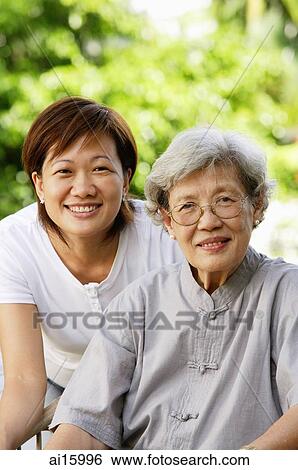 Two generations of women, smiling at camera View Large Photo Image Stock Photograph - Two generations of women, smiling at camera. Fotosearch