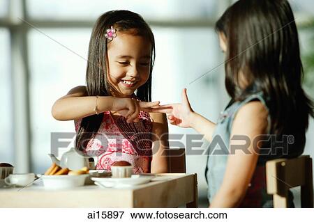 Two girls at tea party, playing hand games View Large Photo Image Stock Photo - Two girls at tea party, playing hand games. Fotosearch