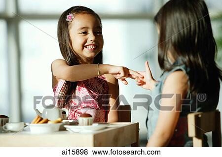 Two girls at tea party, playing View Large Photo Image Stock Photo - Two girls at tea party, playing. Fotosearch