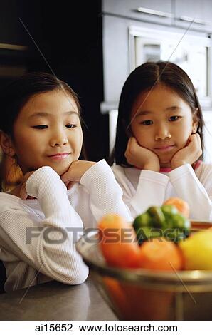 Two girls looking at a bowl of vegetables View Large Photo Image Stock Image - Two girls looking at a bowl of vegetables. Fotosearch