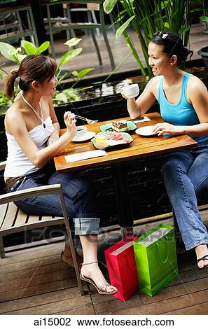 Two women at cafe, having coffee and food View Large Photo Image Stock Image - Two women at cafe, having coffee and food. Fotosearch