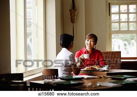 Two women at cafe, having coffee View Large Photo Image Stock Image - Two women at cafe, having coffee. Fotosearch