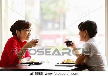 Two women at cafe, sitting face to face, holding drinks View Large Photo Image Stock Photography - Two women at cafe, sitting face to face, holding drinks. Fotosearch