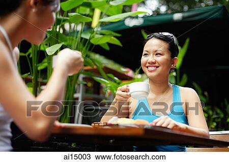 Two women at outdoor cafe, drinking coffee View Large Photo Image Stock Image - Two women at outdoor cafe, drinking coffee. Fotosearch