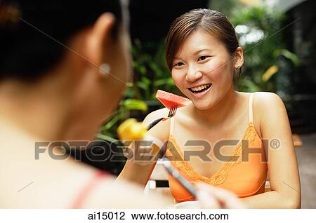 Stock Image - Two women eating, portrait. Fotosearch