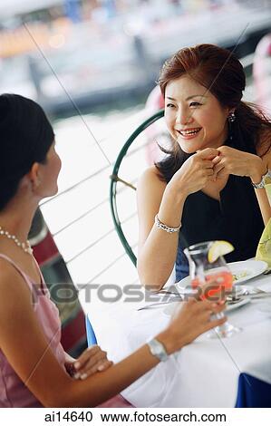 Two women having lunch, smiling View Large Photo Image Stock Image - Two women having lunch, smiling. Fotosearch
