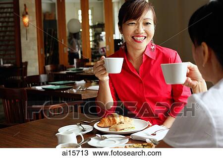 Two women having tea at cafe, over the shoulder view View Large Photo Image Stock Image - Two women having tea at cafe, over the shoulder view. Fotosearch