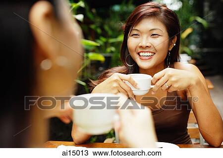 Two women holding coffee cups, over the shoulder view View Large Photo Image Stock Image - Two women holding coffee cups, over the shoulder view. Fotosearch