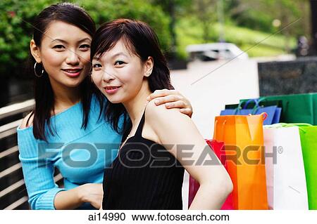Stock Image - Two women looking at camera, portrait. Fotosearch