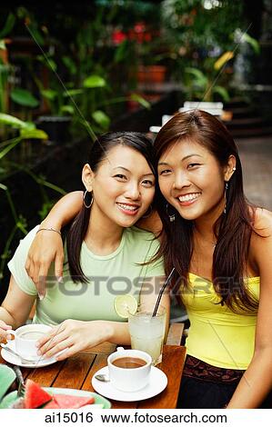 Stock Photograph - Two women, one with arm around the other, looking at camera. Fotosearch
