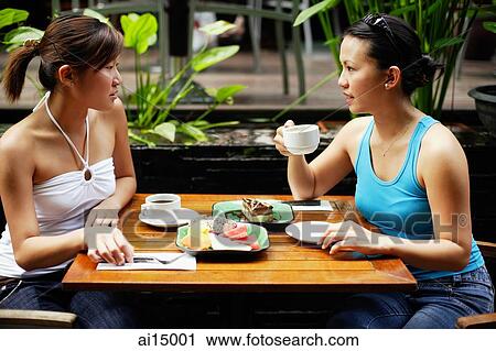 Two women sitting at table, having coffee and fruits View Large Photo Image Stock Image - Two women sitting at table, having coffee and fruits. Fotosearch