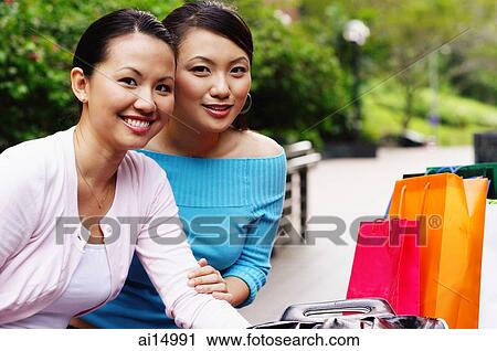 Stock Image - Two women smiling at camera, portrait. Fotosearch