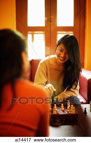 Two young women playing chess View Large Photo Image Stock Photo - Two young women playing chess. Fotosearch