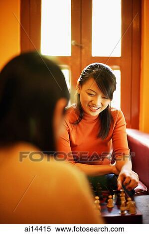 Stock Photography - Two young women sitting, playing chess. Fotosearch