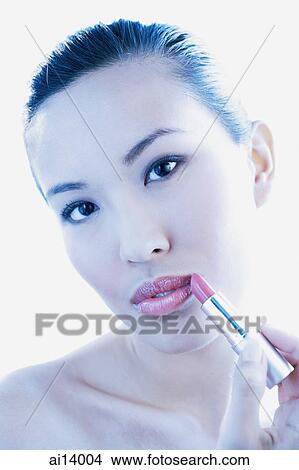 Picture - Woman applying lipstick. Fotosearch