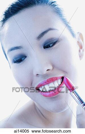Woman applying lipstick, smiling and looking down View Large Photo Image Stock Photography - Woman applying lipstick, smiling and looking down. Fotosearch