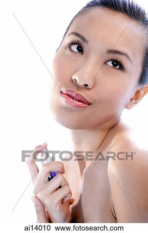 Woman applying perfume, looking away View Large Photo Image Stock Image - Woman applying perfume, looking away. Fotosearch