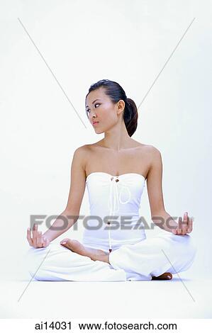 Stock Image - Woman dressed in white, sitting with legs crossed. Fotosearch