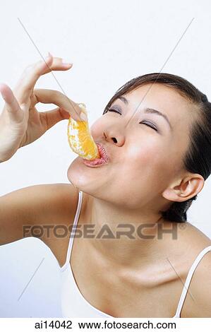 Woman eating orange slice View Large Photo Image Stock Image - Woman eating orange slice. Fotosearch