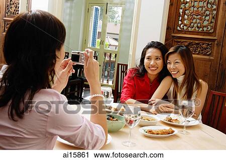 Woman holding camera, taking pictures of friends View Large Photo Image Stock Image - Woman holding camera, taking pictures of friends. Fotosearch