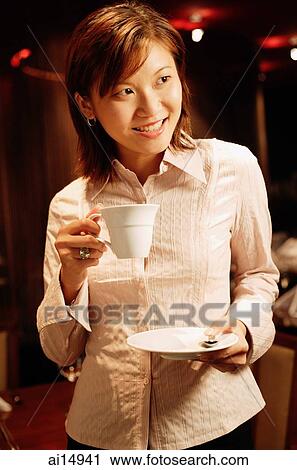 Woman holding cup and saucer, looking away, smiling View Large Photo Image Stock Image - Woman holding cup and saucer, looking away, smiling. Fotosearch