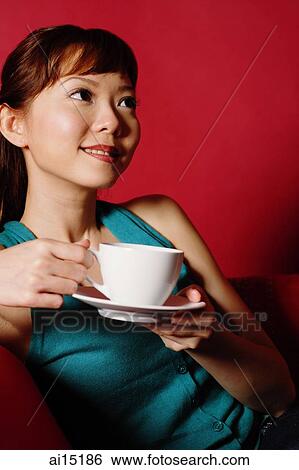 Woman holding cup and saucer, looking away View Large Photo Image Stock Photograph - Woman holding cup and saucer, looking away. Fotosearch