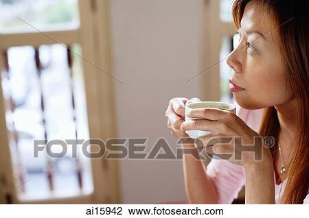 Woman holding cup, looking away View Large Photo Image Stock Image - Woman holding cup, looking away. Fotosearch