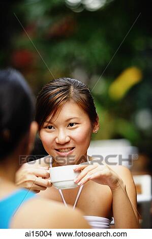 Woman holding cup, over the shoulder view View Large Photo Image Picture - Woman holding cup, over the shoulder view. Fotosearch